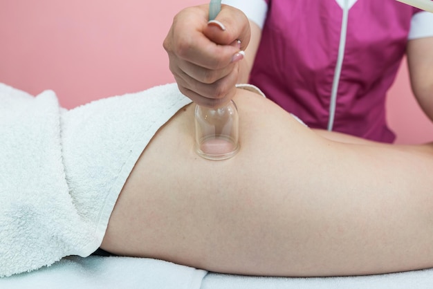 Hardware-Kosmetik Vakuummassageverfahren im medizinischen Schönheitszentrum Nahaufnahme der Anti-Cellulite-Schröpftherapie einer jungen Frau