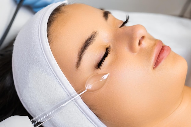 Hardware-Vakuum-Gesichtsmassage für Hautglattheit Frau genießt das Verfahren und erwartet Qualität