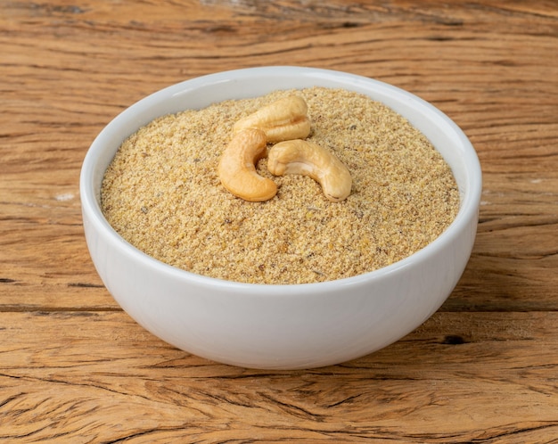 Harina de anacardo en un bol sobre mesa de madera Harina sin gluten