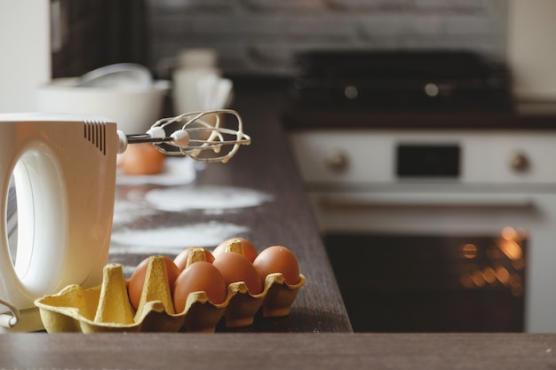 Harina de huevos y batidora en la cocina de casa para hacer pasteles y postres para la familia en el contexto ...