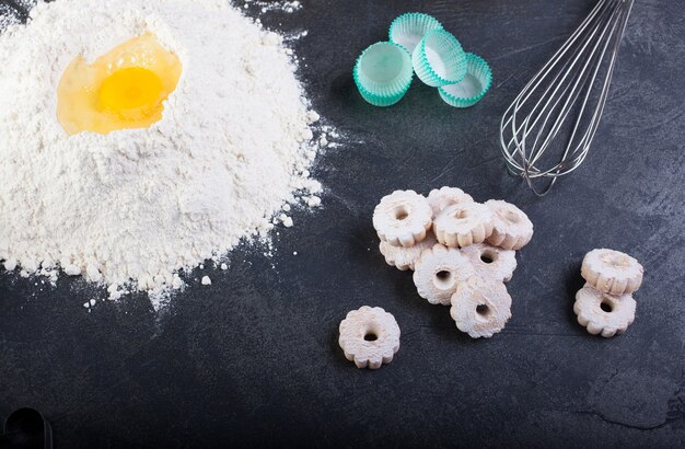 Harina, huevos y canestrelli, galletas de mantequilla italianas utensilios de cocina en el cuadro negro