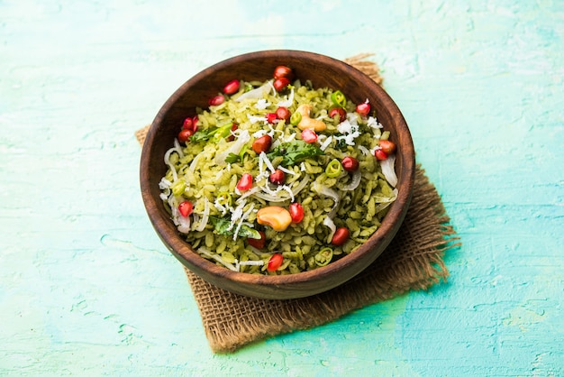 Foto hariyali poha, verde masala pohe o arroz aplanado servido en un recipiente, el enfoque selectivo