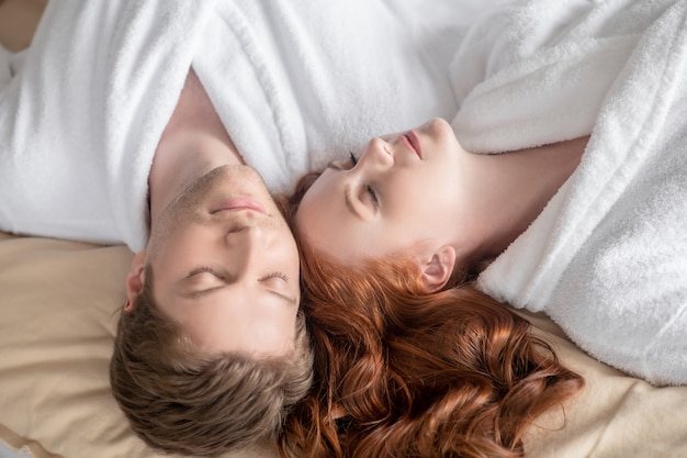 Harmonia. Um homem e uma mulher de branco parecendo relaxados e em paz