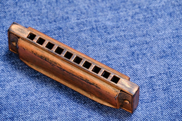 Harmonica-Musikinstrument liegt auf Jeanshosen