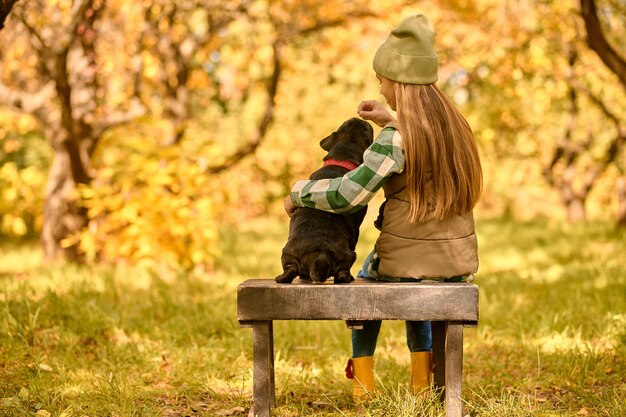 Harmonie. Ein Mädchen sitzt mit ihrem Hund im Park auf der Bank