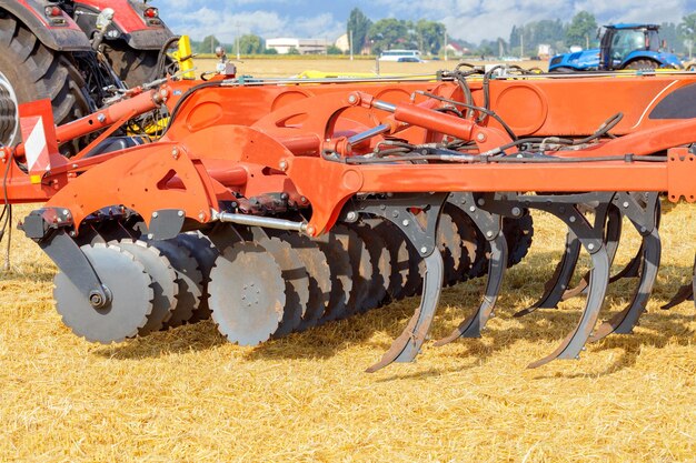 Foto harrow de disco multirrow para trabalho de campo como um engate em um tractor agrícola