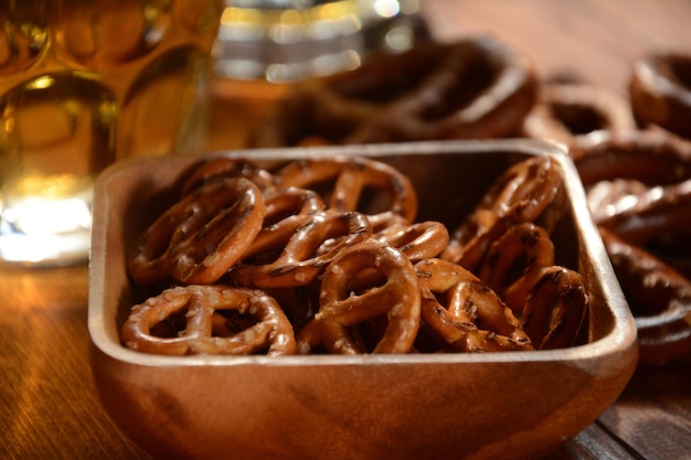 Harte Brezeln oder gesalzene Brezeln Snack für Party auf rustikalem Holztisch mit einem Glas Bier