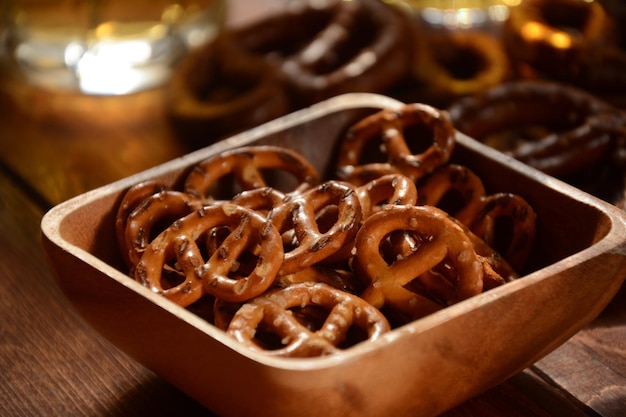 Foto harte brezeln oder gesalzene brezeln snack für party auf rustikalem holztisch mit glas bier