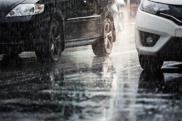 Harter Regen fällt in der Stadt mit verschwommenen Autos. Selektiver Fokus und Farbe getönt.