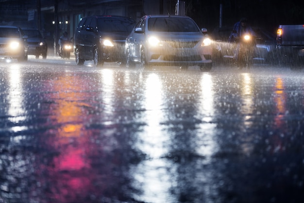 Harter Regenfall nachts mit undeutlichen Autos Selektiver Fokus.