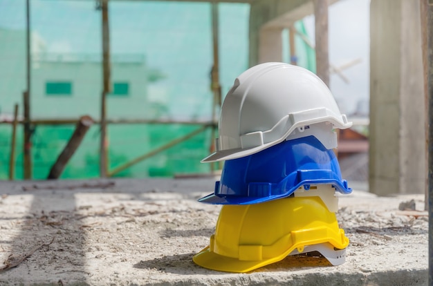 harter Schutzhelm für Sicherheitsunfallstapel auf Boden am Arbeitsplatz im Baustellegebäude