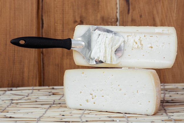 Hartkäsescheibe, Ziegenmilch mit Käsemesser schneiden