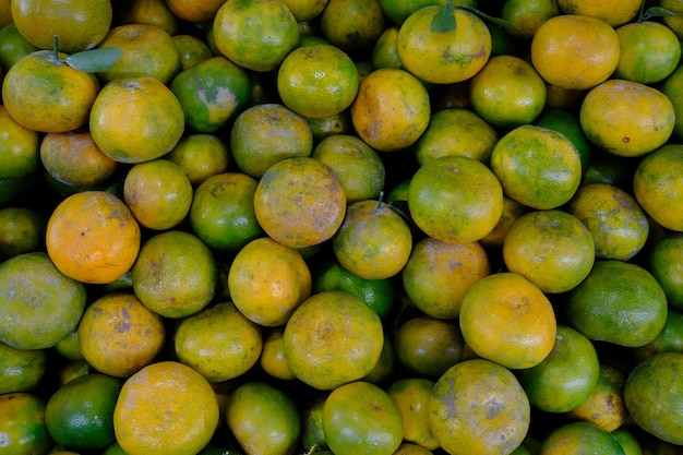 Haufen der frischen grünen gelben Orange auf dem Markt.