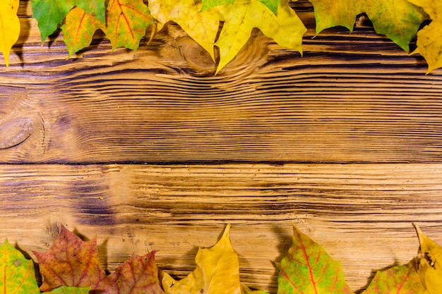 Haufen der gelben Ahornblätter auf einem Holztisch Draufsicht