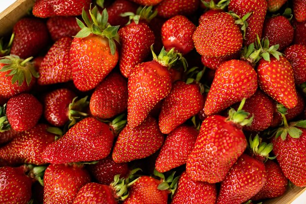 Foto haufen erdbeeren in einer holzkiste