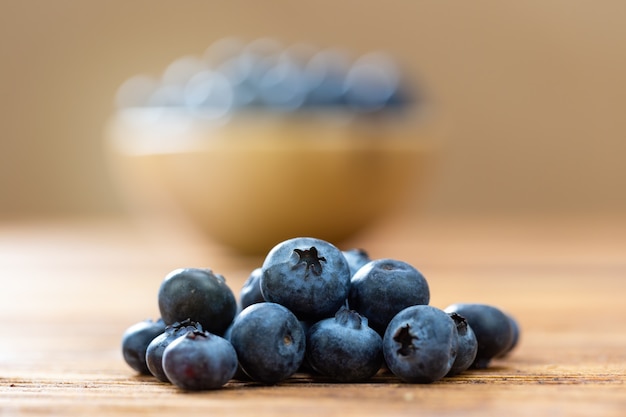 Haufen frischer Blaubeeren, die auf Holztisch liegen