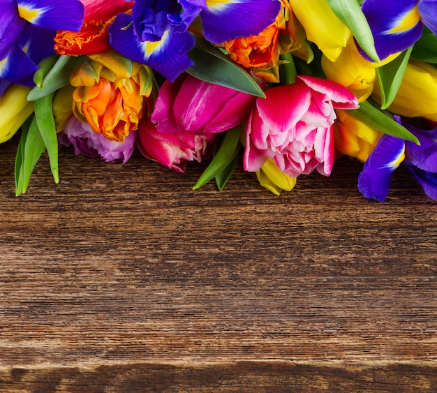 Haufen frischer frühlingstulpen und iris boder mit kopierraum auf holz