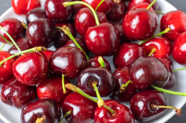 Haufen frischer reifer roter Kirschbeeren auf weißem Teller topview Bio-Lebensmittel aus der Region