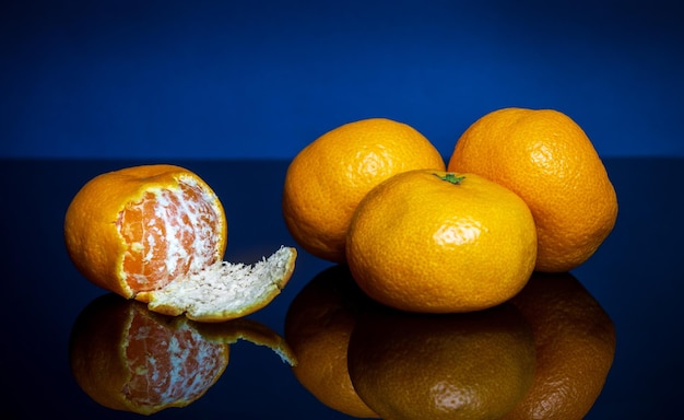 Haufen reife gelbe Mandarinen oder Mandarinen auf blauem Hintergrund Idee Clementinen Dieta