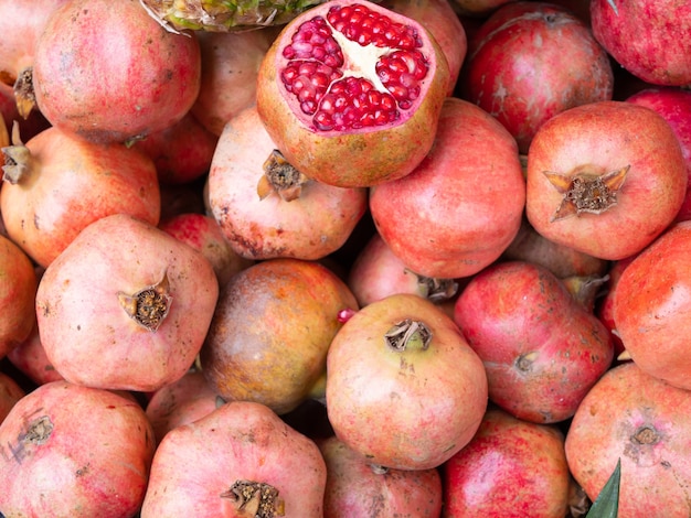 Haufen reifer Granatäpfel mit in Scheiben geschnittenen oben auf dem Ostbasar