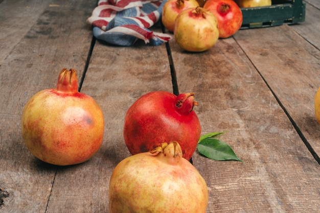 Haufen reifer Granatapfel auf hölzernem backgfround