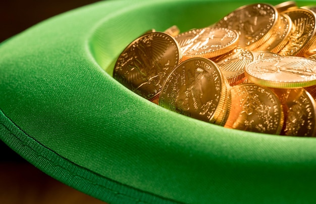 Haufen reiner Goldmünzen im grünen Hut St. Patricks Day