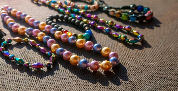 Haufen von farbigen hellen Schmuckperlen auf dunklem Hintergrund Verschiedene Edelsteine Perlen Halskette Jewel Halskette modernes Modemuster oder Textur Schmuckhintergrund
