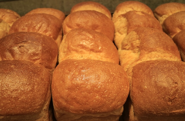 Haufen von flaumigen frischen gebackenen Brotlaiben, oben geschlossen für Hintergrund, Beschaffenheit