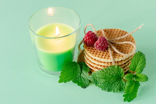 Haufen von Karamell runden holländischen Waffeln mit Himbeeren auf Holztisch mit Kerze.