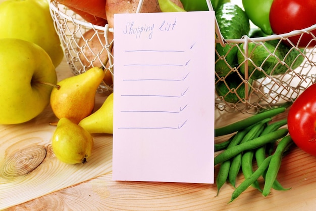 Foto haufen von obst und gemüse mit einkaufsliste auf dem tisch aus nächster nähe