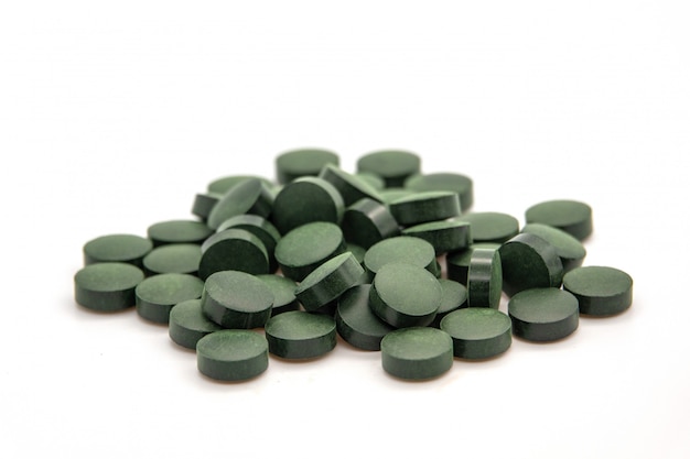 Haufen von Spirulina Pulver und Kapseln