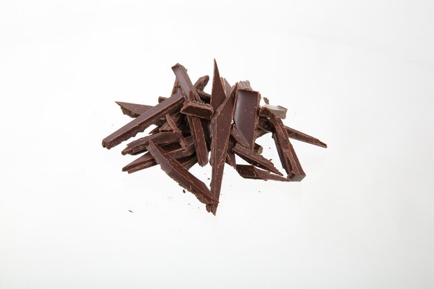 Haufen zerbrochener Schokoladenstücke isoliert auf weiß