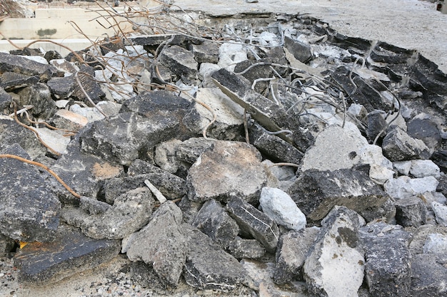 Haufen zerschlagener Asphaltschutt und rostiger Bewehrungsstahl