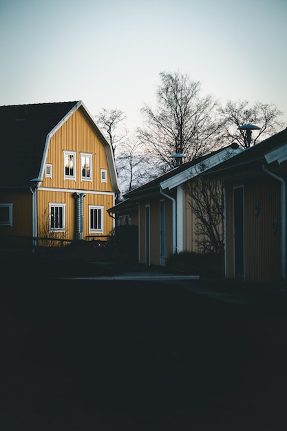 Haus inmitten nackter Bäume und gegen den Himmel in der Dämmerung