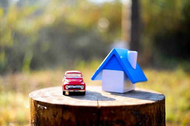 Haus und kleines Spielzeugauto. Legen Sie den Baumstamm in den Wald und die Berge im Winter an