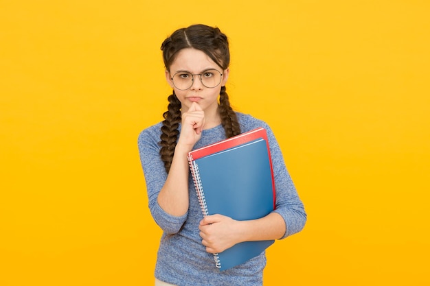 Hausaufgaben entwickeln Lerngewohnheiten Ernstes Mädchen hält Bücher Nachdenken über Hausaufgaben Hausaufgabe Hausaufgabenbetreuung Hausaufgabenclub Schule und Bildung Schülerroutine Vorbereitung auf die nächste Unterrichtsstunde