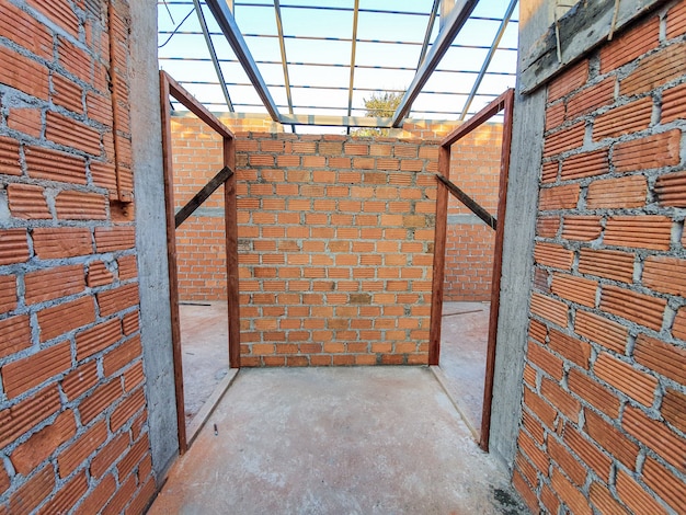 Hausbaustelle Verwenden Sie rote Ziegelsteine als Wand. Mit Stahldachrahmen Betonsäule.