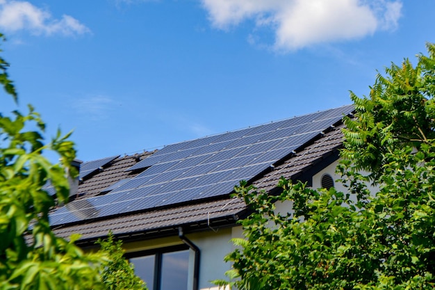 Hausdach mit Photovoltaikmodulen. Historisches Bauernhaus mit modernen Sonnenkollektoren auf Dach und Wand