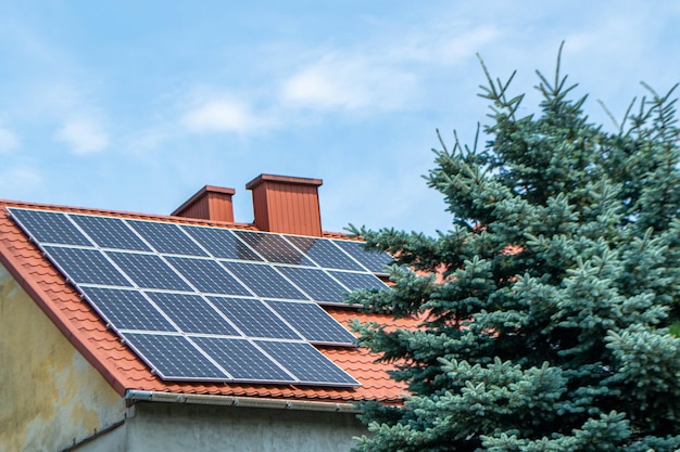 Hausdach mit Photovoltaikmodulen. Historisches Bauernhaus mit modernen Sonnenkollektoren auf Dach und Wand