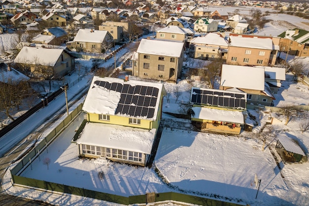 Hausdach mit Sonnenkollektoren im Winter mit Schnee bedeckt