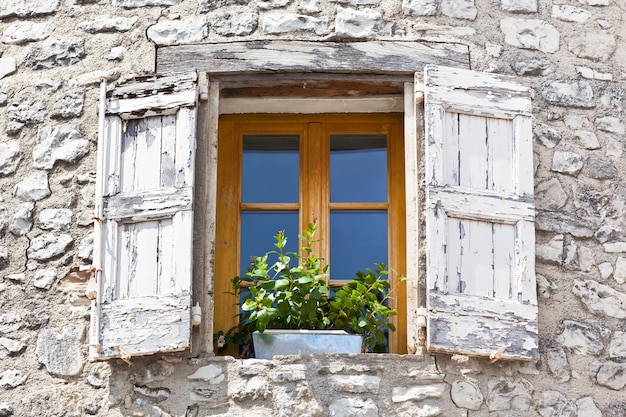 Hausfassade mit weißen Fensterläden in Frankreich