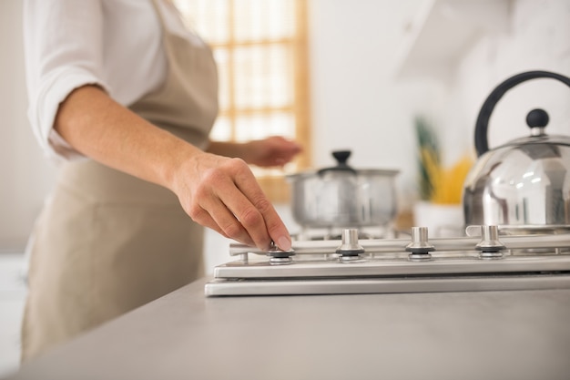 Hausfrau in der Schürze, die in der Küche kocht