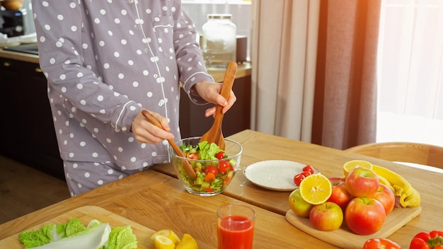 Hausfrau mischt Gemüsesalat und kümmert sich um die Gesundheit