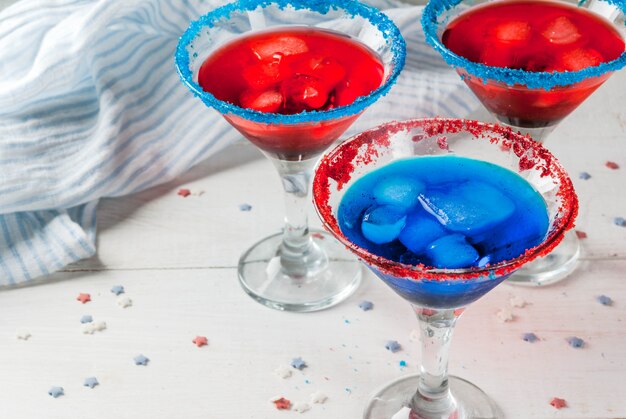 Hausgemachte alkoholische Cocktails, Punsch in traditionellen Farben - rot, blau, weiß. Mit Eis. Auf dem Küchentisch zu Hause. Kopieren Sie Platz