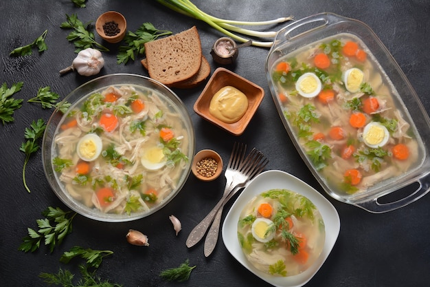 Hausgemachte Aspik, geliertes Hühnerfleisch mit Kräutern und Karotten. Traditionelles russisches Gericht Holodets. Serviert mit Brot und Senf oder/und Meerrettich