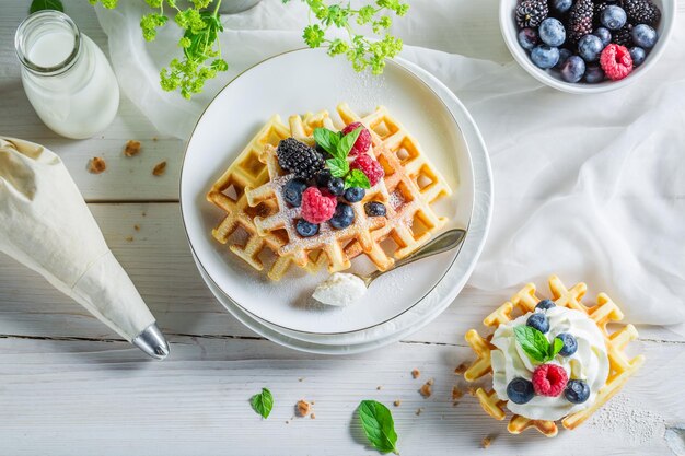 Hausgemachte Beeren mit Waffeln und Schlagsahne