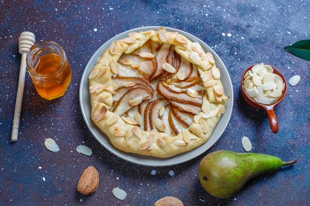 Hausgemachte Birnen-Galette-Torte mit Mandelblättern und frischen reifen grünen Birnen