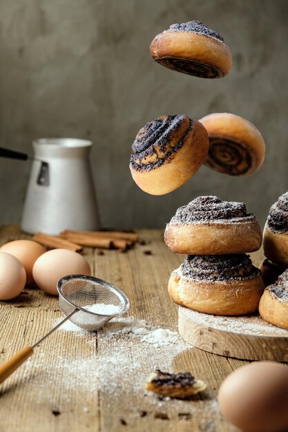 hausgemachte Brötchen mit Mohn auf einem Holztisch