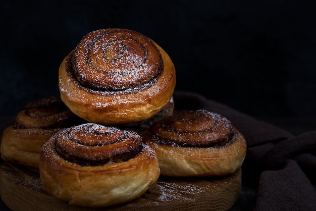 Foto hausgemachte brötchen mit zimt und puderzucker, hausgemachtes gebäck, selektiver fokus, nahaufnahme