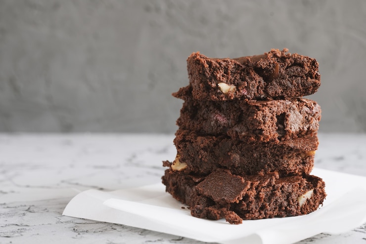 Foto hausgemachte brownies mit nüssen auf weißem papier serviert
